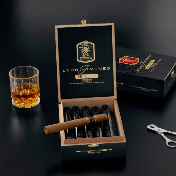Packing of Leon Jimenes Prestige cigars, with a cutter and a glass of rum.